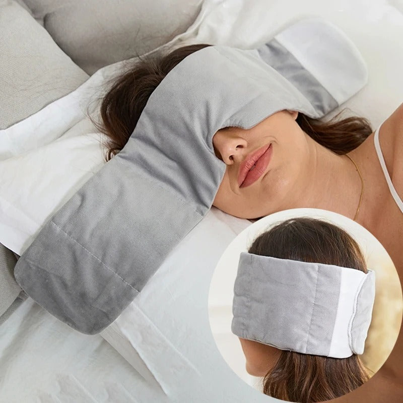Woman lying down with a gray eye mask and pillow, with an inset showing the product. Weighted Eye Mask 